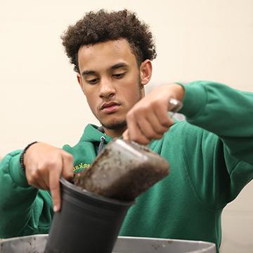 Horticulture student potting a plant