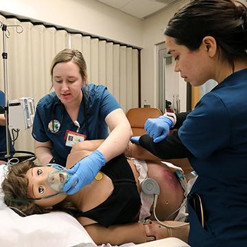 护理学生在模拟假人上练习呼吸护理