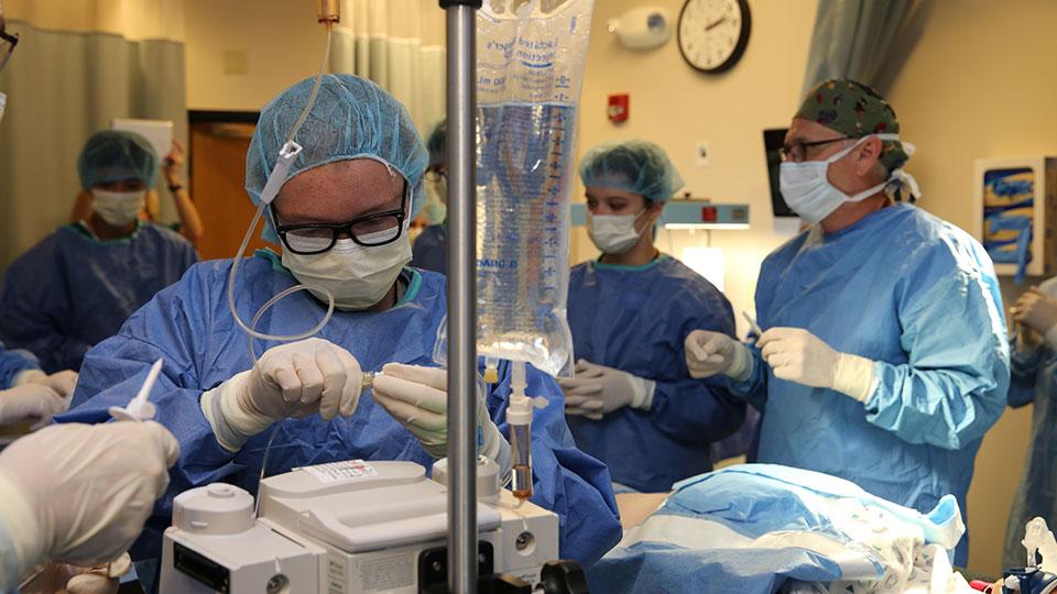 在手术室里，一个人将静脉注射管连接到监视器上